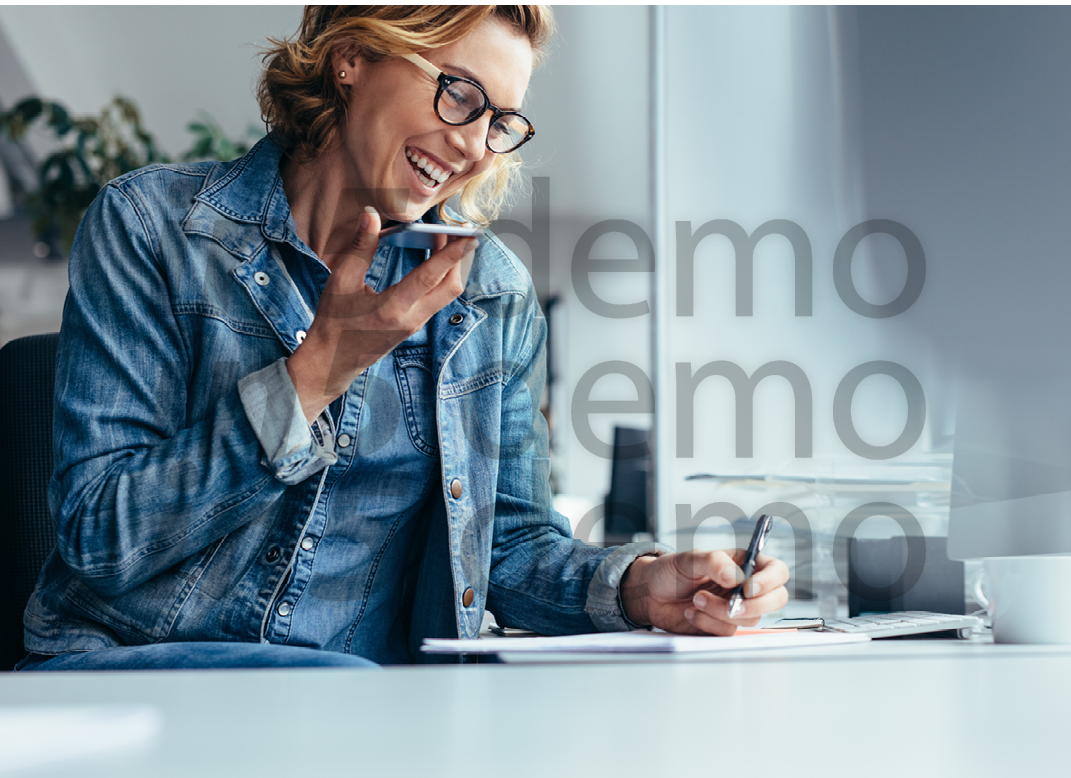 Young female executive working in office  Smiling young businesswoman talking on cellphone and writing notes 