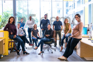 Portrait of confident business team in creative office  Smiling multi-ethnic male and female professionals are at workplace  They are wearing smart casuals 